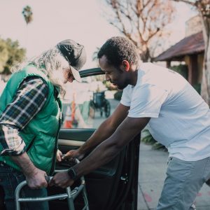 Man Assisting Person with Walker